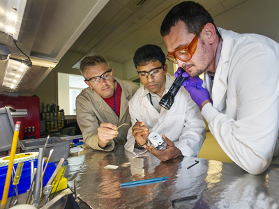 Attention to detail: Simon Billinge, Milinda Abeykoon, and Emil Bozin prepare to mount a sample for powder diffraction analysis.