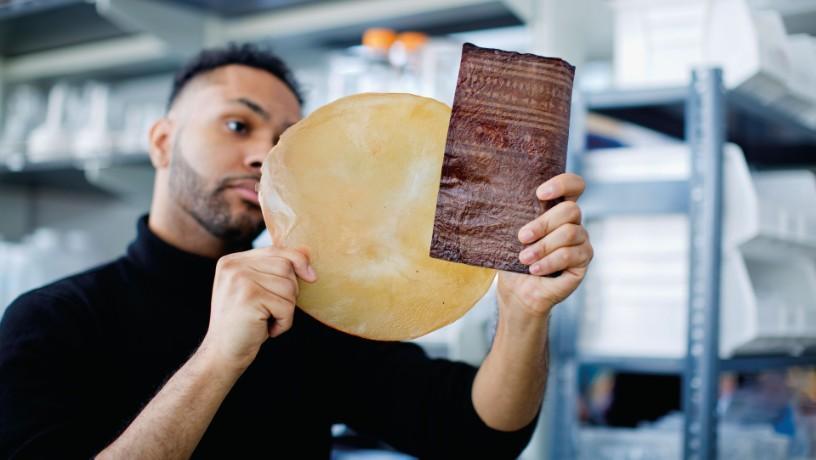 A studnent holding up a sample of compostable bioleather.