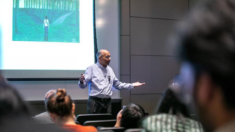 Rajesh Jain gesturing to his audience. Attendees look on from their seats.