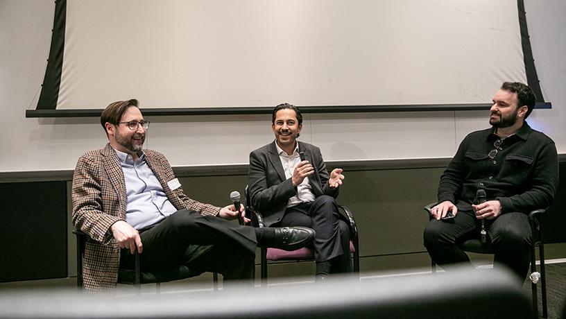 Three people sitting in chairs holding microphones. 