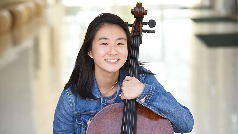 Jackie Yang smiling with a cello