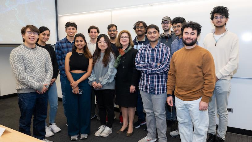 Georgia Papathomas posing for a photo with 13 Columbia Engineering students