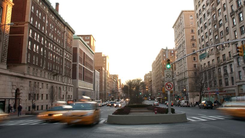 Broadway in Manhattan. Blurred out cars drive down the road