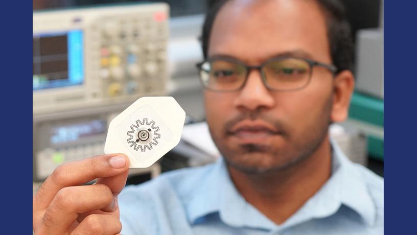 Photo of researcher Rajaram Kaveti holding the water-powered, electronics-free dressing (WPED)