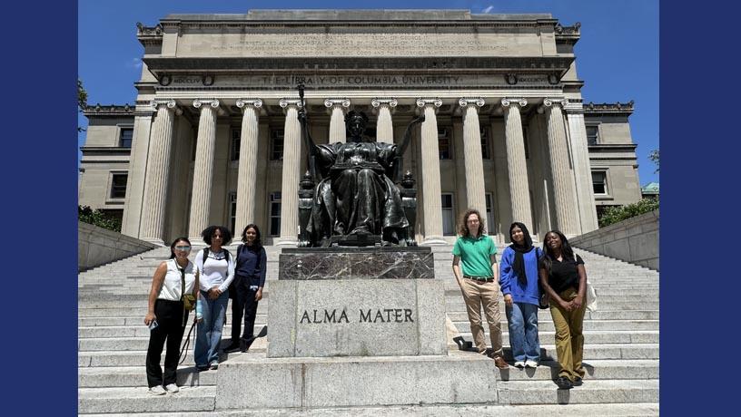 Picture of students next  to an alma mater statue